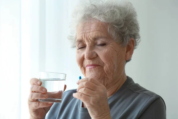 Ältere Frau nimmt Tablette — Stockfoto