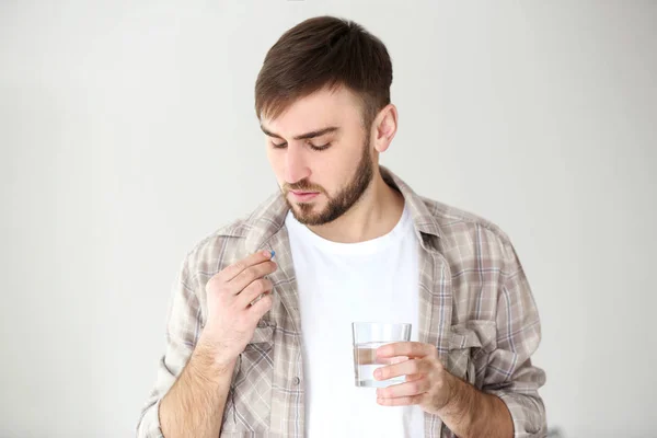 Hombre sosteniendo píldora y vaso de agua —  Fotos de Stock