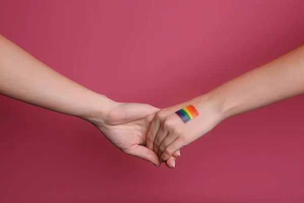 Manos femeninas con bandera de arco iris pintada — Foto de Stock