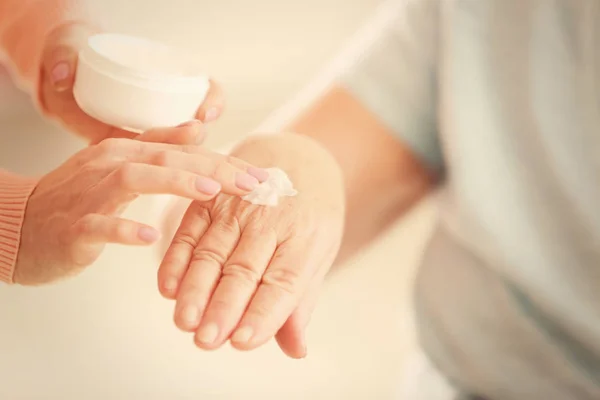 Applying cream on hands of elderly patient — Stock Photo, Image