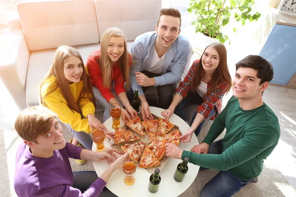 Vrienden met smakelijke pizza en bier — Stockfoto