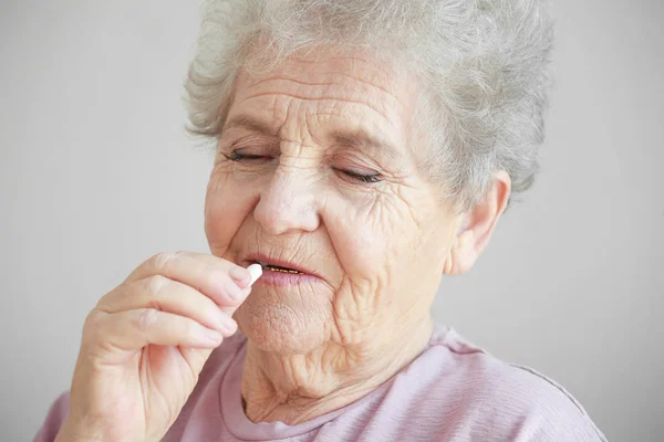 Ältere Frau nimmt Tablette — Stockfoto