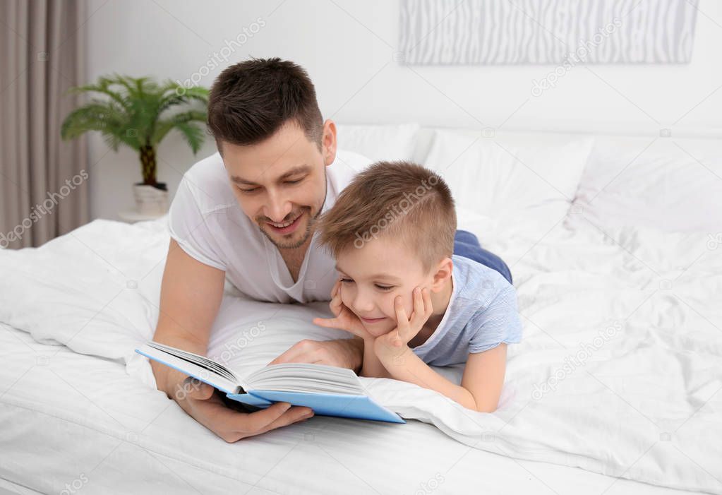 Dad and son reading interesting book  