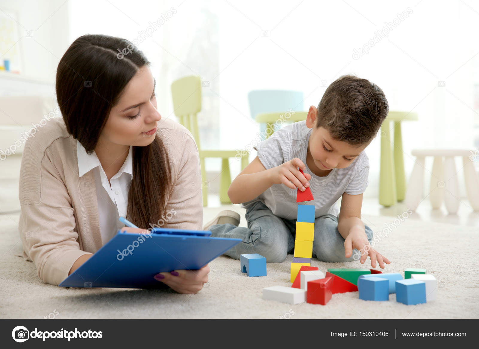 Young child psychologist working with little boy Stock Photo by