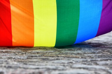 Gay flag over paving blocks clipart