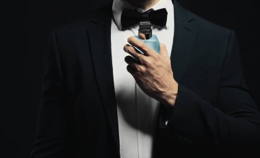 Parfüm kullanan yakışıklı genç adam.  