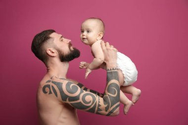 Şirin Bebek renk arka plan üzerinde tutarak dövmeli yakışıklı genç