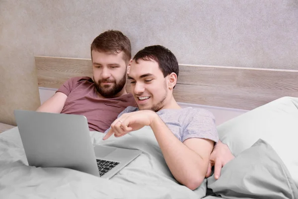 Homosexuální pár, ležící na posteli — Stock fotografie