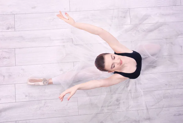 Joven bailarina estirándose en el suelo — Foto de Stock
