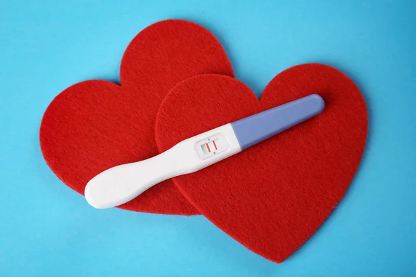 Pregnancy test and red hearts — Stock Photo, Image