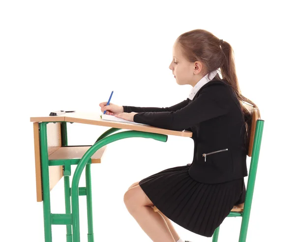 Schülerin sitzt am Schreibtisch auf weißem Hintergrund — Stockfoto