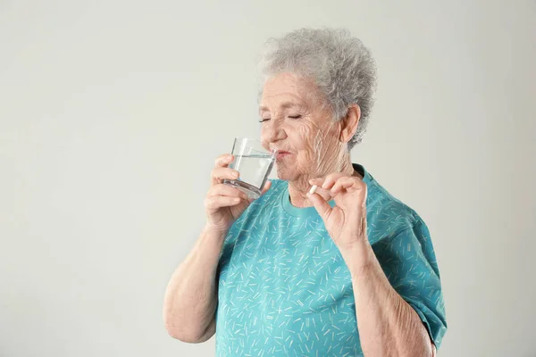 Mujer de edad avanzada tomando píldora — Foto de Stock