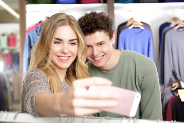 Jovem casal feliz tomando selfie na loja moderna — Fotografia de Stock