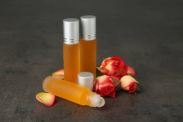 Бутылки с духами и бутонами роз
