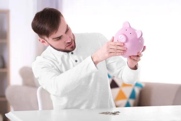 Ung man med spargris bank — Stockfoto