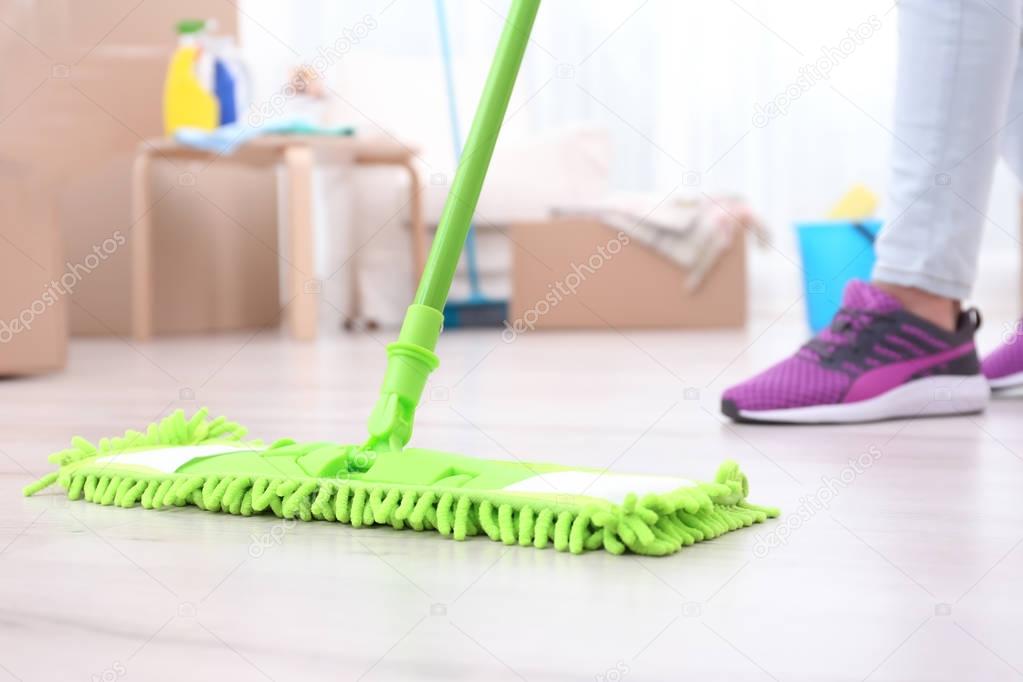 Woman moping floor in home, closeup