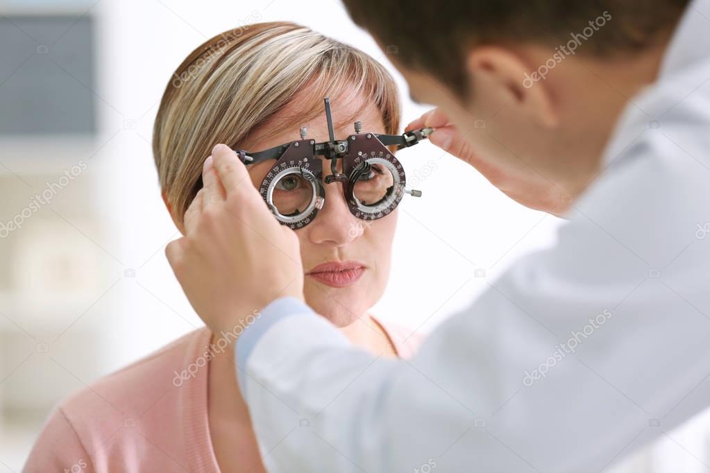 Ophthalmologist examining eyes of woman 