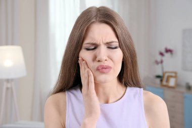 Diş ağrısı çeken genç bir kadın. 