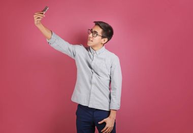 Genç Asyalı adam selfie çekiyor. 