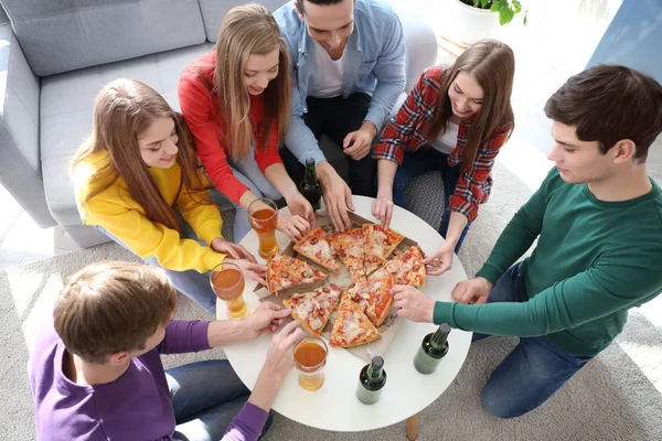 Vrienden met smakelijke pizza en bier — Stockfoto