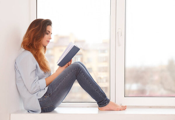 Beautiful young woman reading book 