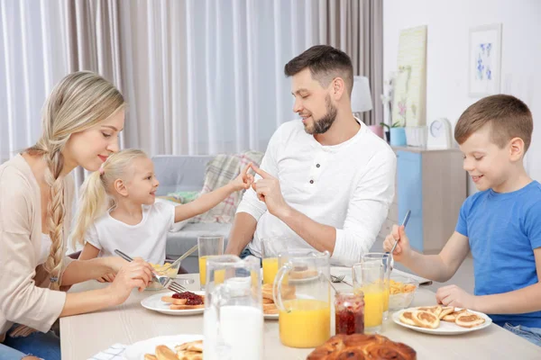 Счастливая семья завтракает на кухне — стоковое фото