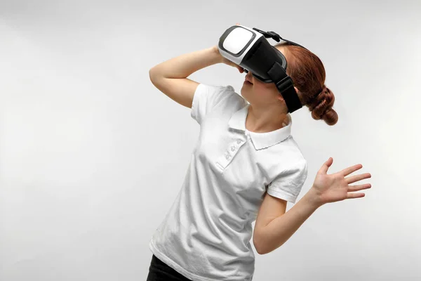 Retrato de niña divirtiéndose con auriculares de realidad virtual sobre fondo claro — Foto de Stock