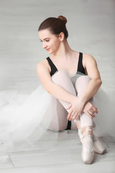 Jonge ballerina zittend op de vloer — Stockfoto