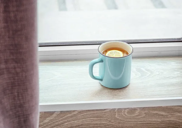 Copa de té con limón en el alféizar de la ventana —  Fotos de Stock