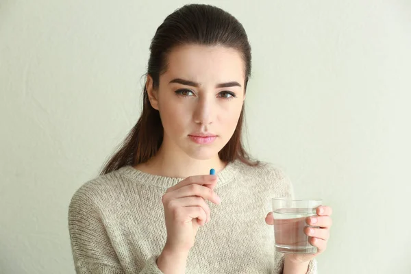 Beautiful young woman taking pill — Stock Photo, Image