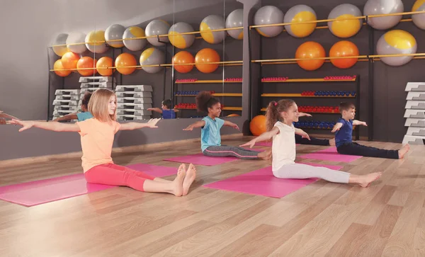 Los niños en la lección de educación física en el gimnasio escolar —  Fotos de Stock