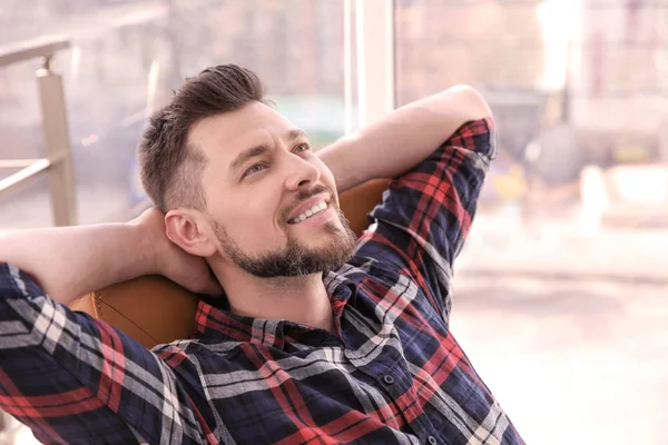 Feliz joven descansando en sillón —  Fotos de Stock