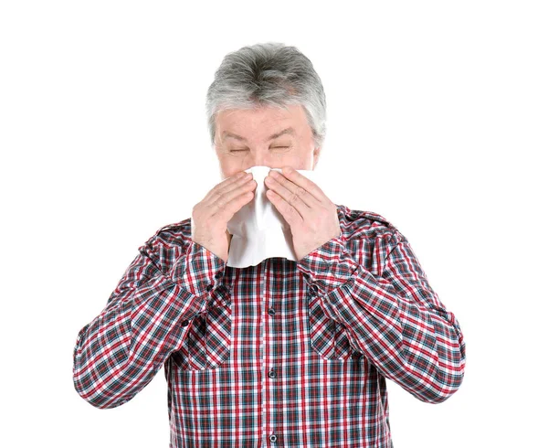 Senior man blowing nose on tissue against white background — Stock Photo, Image