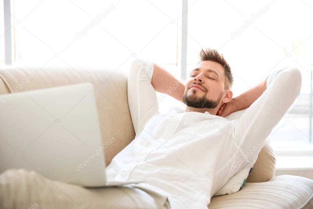 young man lying  with laptop
