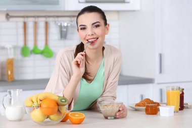 Genç bayan kahvaltı yapıyor. 