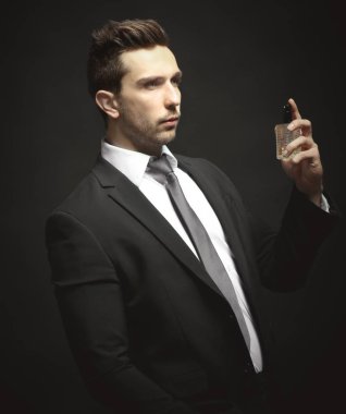 Parfüm kullanan yakışıklı genç adam. 