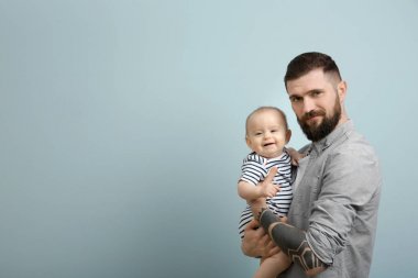 Şirin Bebek ışık arka plan üzerinde tutarak dövmeli yakışıklı genç