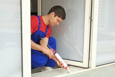 worker sealing joints of office window clipart
