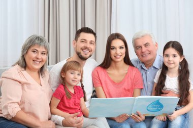 Kitap odasında kanepede oturan ile mutlu aile