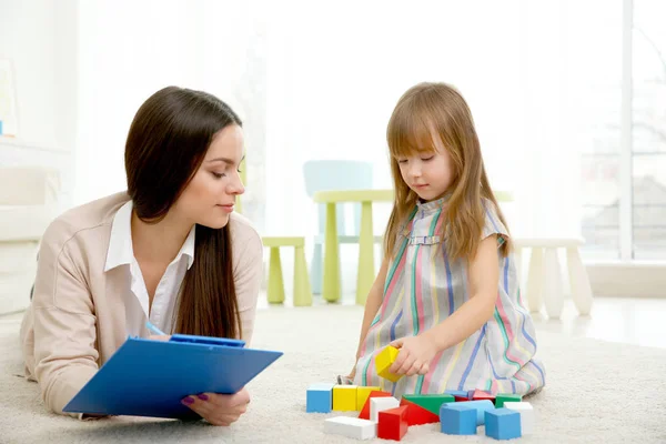 Junge Kinderpsychologin arbeitet mit kleinem Mädchen — Stockfoto