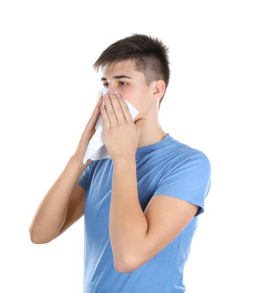 Young man blowing nose on tissue against white background — Stock Photo, Image