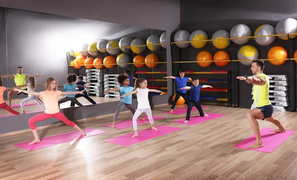 Los niños en la lección de educación física en el gimnasio escolar —  Fotos de Stock