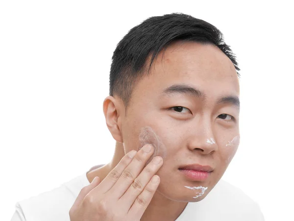 Jovem homem asiático aplicando creme — Fotografia de Stock