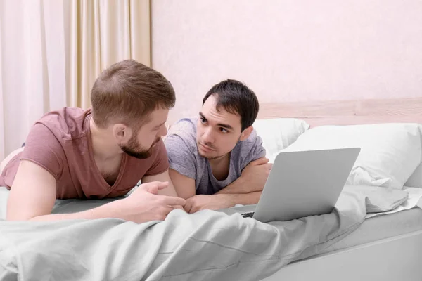 Homosexuální pár, ležící na posteli — Stock fotografie