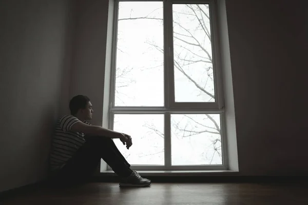 Bel homme déprimé assis sur le sol à la maison — Photo