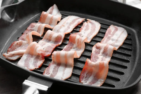 Tranches de bacon cru sur le gril — Photo