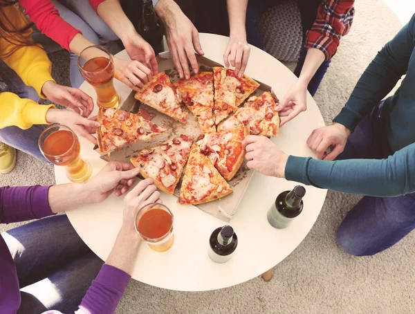 Vrienden met smakelijke pizza en bier thuis partij — Stockfoto