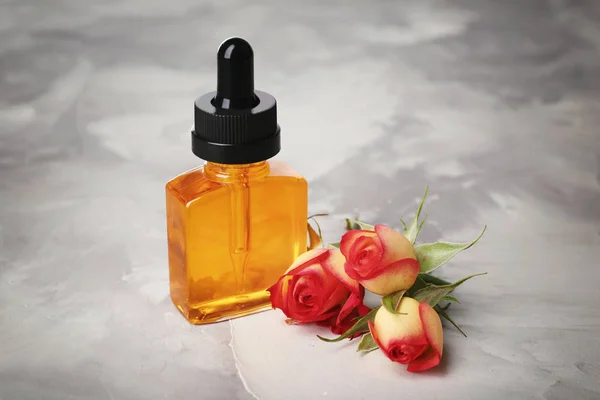 Lahvička s parfémem ropy a růžových poupat — Stock fotografie