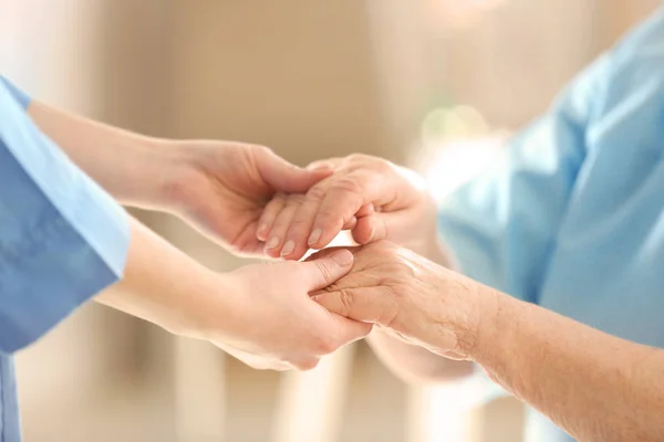 Doctor holding hands of elderly woman — Stock Photo, Image