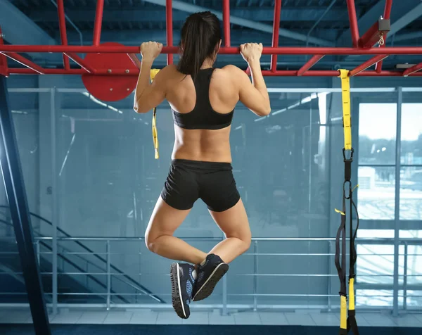 Entrenamiento de mujer atlética en barra horizontal en gimnasio — Foto de Stock